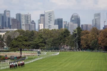 29.09.2023, Saint Cloud, Paris, FRA - Horses and jockeys during a race in front of the skyline of La Defense. Saint Clou